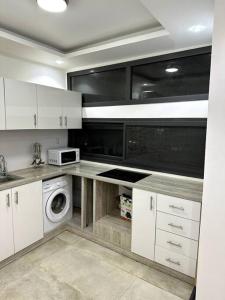 达喀尔Appartements aux Mamelles的厨房配有白色橱柜和洗衣机。
