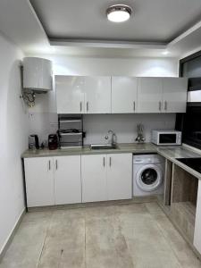 达喀尔Appartements aux Mamelles的厨房配有白色橱柜和洗衣机。
