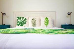 波哥大维佳酒店的一张带绿色和白色床单及枕头的床