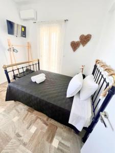 易莫洛林Petalou House的一间卧室配有一张带两个枕头的黑色床。
