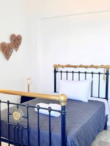 易莫洛林Petalou House的卧室配有一张带金属框架的床,墙上有心
