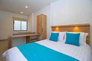 昆卡APART HOTEL CASA BLANCA的一间卧室配有一张带蓝白色枕头的大床