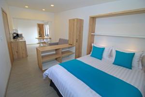 昆卡APART HOTEL CASA BLANCA的卧室配有蓝色和白色的床和书桌。