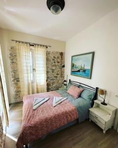 毕达哥利翁Stone Villa的一间卧室配有一张床,上面有两条毛巾