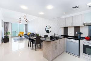 迪拜White Sage - Incredible Full Sea and Dubai Eye View in Marina的厨房以及带桌椅的起居室。