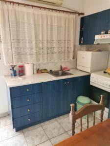 卡梅纳维洛拉Spitaki mou的厨房配有蓝色橱柜和水槽