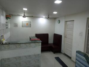 孟买Hotel janata Residency的一间设有两把椅子和一张书桌的等候室