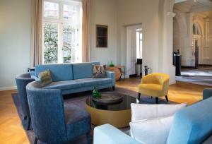 阿姆斯特丹Pestana Amsterdam Riverside的客厅配有蓝色的沙发和椅子