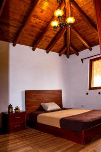 里奥班巴Comunidad La Moya, Calpi的一间卧室设有一张床和木制天花板