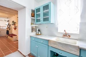 卡尔帕索斯Olive Grove Cottage的厨房配有蓝色橱柜和水槽