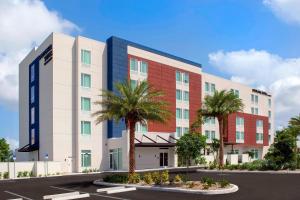 蓬塔戈尔达SpringHill Suites by Marriott Punta Gorda Harborside的停车场内棕榈树酒店 ⁇ 染