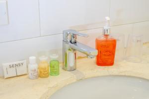 波哥大维佳酒店的浴室水槽配有肥皂和水龙头