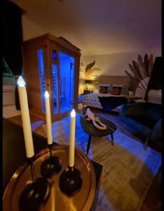 马孔Escapade Mâconnaise Spa-Sauna-Ciel de pluie tropicale-Champagne Nuit Romantique的客厅,桌子上放着三根蜡烛