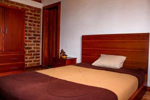 里奥班巴Comunidad La Moya, Calpi的一间卧室设有一张大床和砖墙