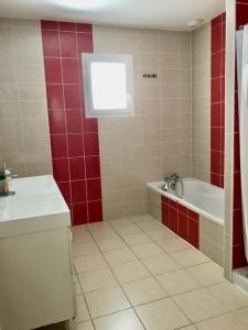 卡尔康Maison piscine 4 ch Carcans Médoc Bassin Arcachon的一间带红色墙壁、浴缸和水槽的浴室