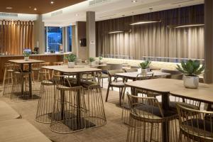 梅德福SpringHill Suites by Marriott Medford Airport的一间带桌椅的餐厅和一间酒吧