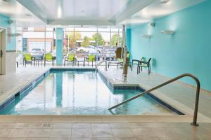 梅德福SpringHill Suites by Marriott Medford Airport的大楼内一个带桌椅的游泳池