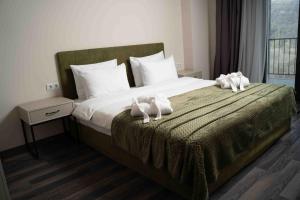 萨克德佐尔镇Forest Apartments Hotel的一间卧室,床上有毛巾动物