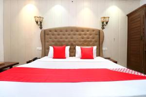 伯蒂亚拉OYO Heritage Corner的一间卧室配有一张带红色枕头的大床