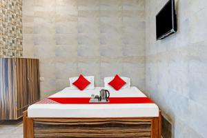 比拉斯布尔Flagship New Mansi Hotel的一间卧室配有一张带红色枕头的床和一台电视。