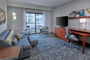 印第安纳波利斯Courtyard by Marriott Indianapolis Castleton的一间客厅,客厅配有沙发和一张书桌,位于酒店的房间