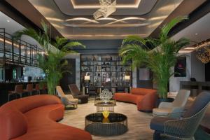 伊兹密尔Izmir Marriott Hotel的大堂配有橙色家具和棕榈树