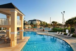 默特尔比奇Sheraton Broadway Resort Villas的度假村的游泳池,带椅子和公寓