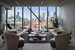 墨尔本AC Hotel by Marriott Melbourne Southbank的带沙发的客厅,享有城市美景