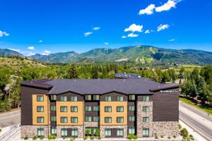 斯廷博特斯普林斯Residence Inn by Marriott Steamboat Springs的享有公寓大楼的空中景致,以群山为背景