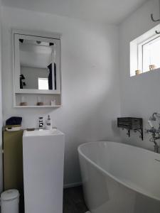 FlateyriFlateyri guesthouse的白色的浴室设有浴缸和水槽。