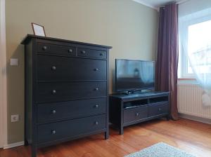 勒伯尔斯塔芬霍夫罗贝尔公寓的一间客房内的黑色梳妆台,配有平面电视