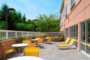 州学院州立学院费尔菲尔德客栈 的一座配有黄色桌椅的庭院和一座建筑