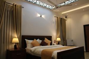 康提Sky Gate kandy的一间卧室配有一张床和两盏灯及窗帘