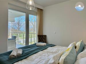 扎马迪Sunshine Resort Blue Apartman的一间卧室设有一张大床和一个大窗户