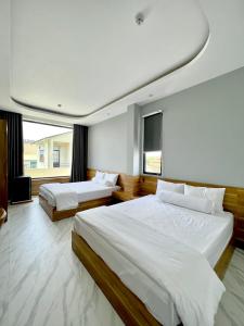 Bình ThủyBITA HOTEL CẦN THƠ的一间卧室设有两张床和大窗户