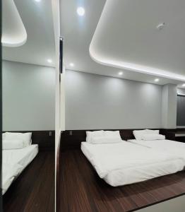 Bình ThủyBITA HOTEL CẦN THƠ的配有2张床的带白色床单和枕头的客房