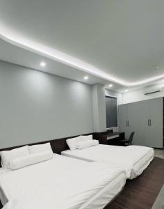 Bình ThủyBITA HOTEL CẦN THƠ的带电视的客房内的2张白色床