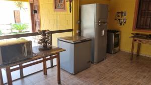 古里里CASA AMARELA Beira Rio Guriri的厨房配有冰箱和电视桌。