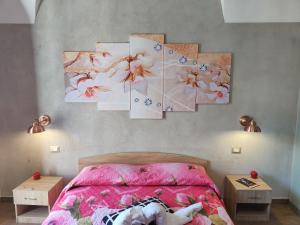 卡塔尼亚Pantaleone Holiday House的卧室配有一张壁挂着四幅画作的床