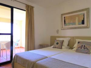 丰沙尔金塔梅多斯霍蒙斯酒店的一间卧室设有一张大床和一个窗户。