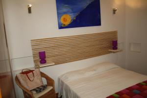 Santa LuciaLos Verdiales的卧室配有一张床,墙上挂有绘画作品