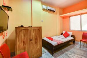 RourkelaSuper OYO Hotel Priyal Amrit Sagar的小房间设有床铺和电视