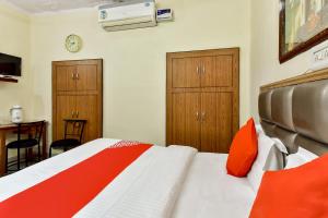 焦特布尔Super OYO Dev Villas Guest House的一间卧室配有一张床和两个木制橱柜。
