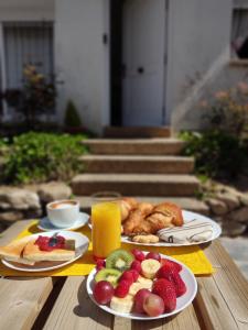 CirueñaLa casa de la Plaza - WIFI - Barbacoa - Chimenea的一张桌子,上面放着两盘水果和一杯橙汁