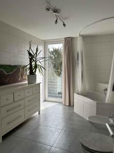 科隆House Susanne的白色的浴室设有浴缸、水槽和浴缸。