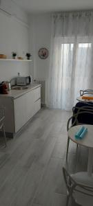 巴里Le Gemelle的厨房配有白色橱柜和桌椅
