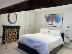 康格尔顿Dove House的卧室配有一张床,墙上挂着一幅树画