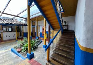 萨兰托Hostal Ciudad de Segorbe的学校走廊,有蓝色和黄色的墙壁和楼梯