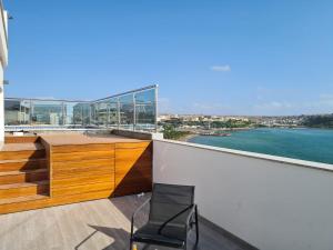普拉亚Cazinos Apartamento的阳台的椅子,享有水景