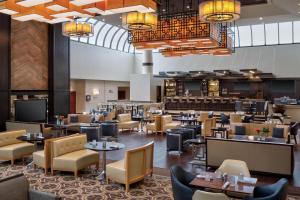 欧文喜来登DFW机场酒店的一个带桌椅的餐厅的大堂